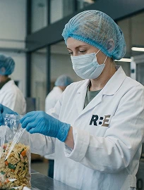 Сотрудница фабрики-кухни RBE фасует продукцию